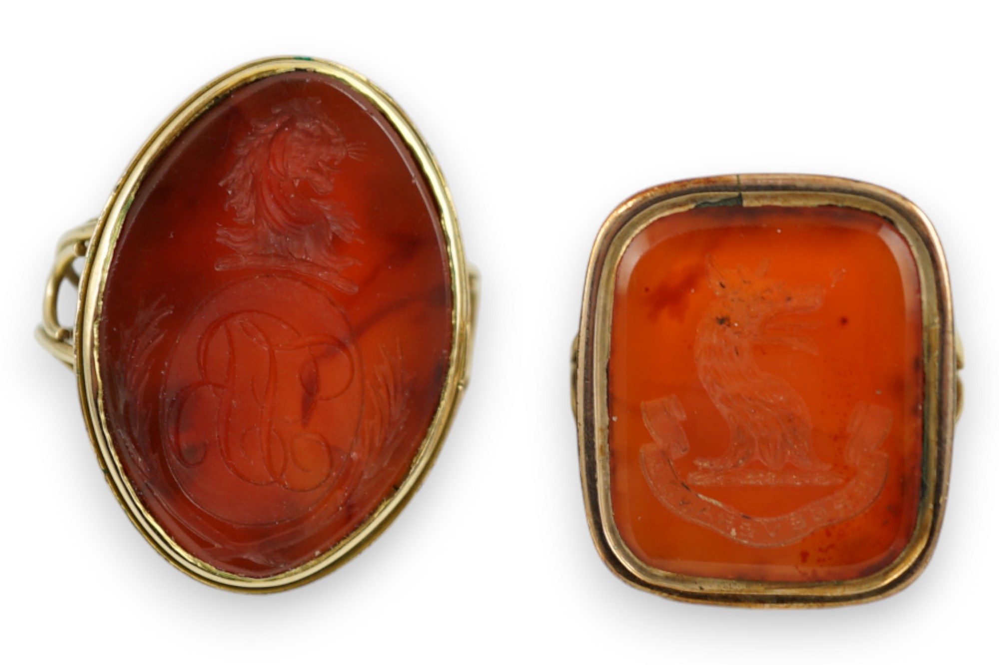 Two Victorian yellow metal and agate set intaglio rings, both matrix carved with a crest, one with monogram also, sizes K and L, gross weight 21.5 grams.